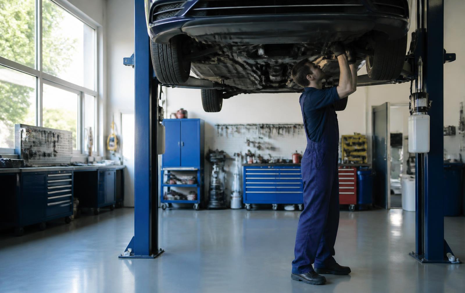 Autokorjaamon halli, auto nosturilla